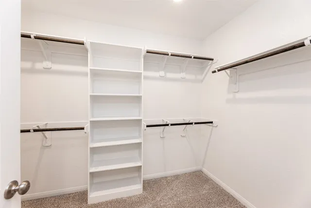 a view of walk in closet with empty racks