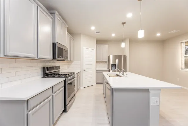 a open kitchen with kitchen island a sink stainless steel appliances and cabinets