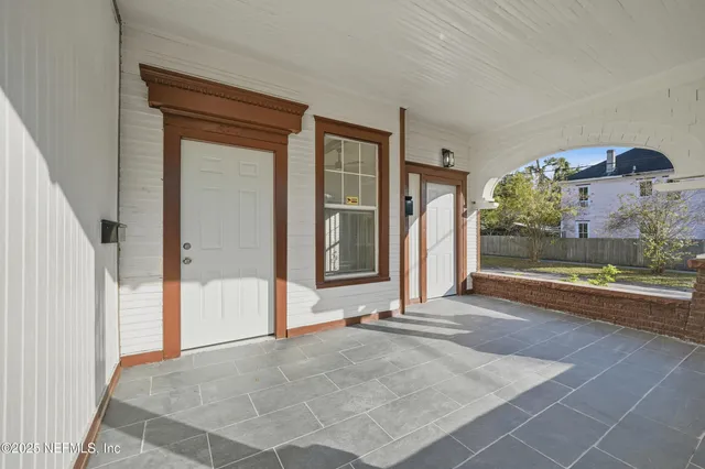 a view of empty room with wooden floor fireplace and a window