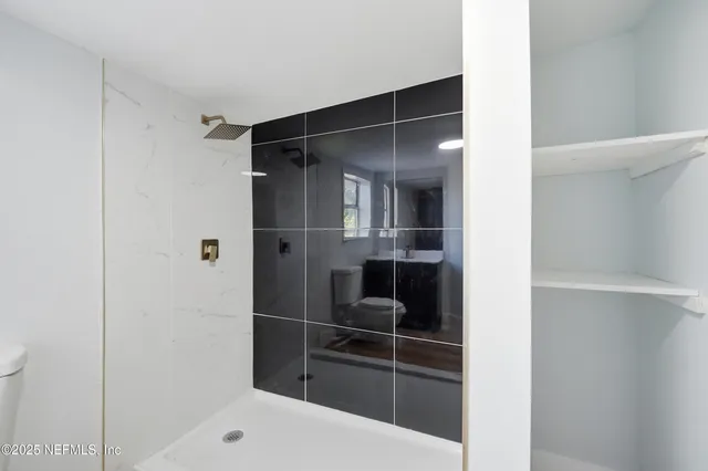 a bathroom with a toilet a sink and shower