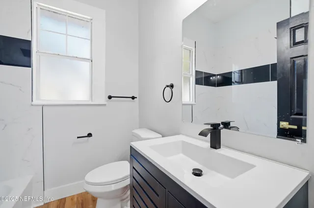 a bathroom with a sink toilet and mirror
