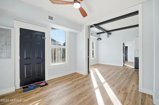 a view of a big room with wooden floor and a kitchen