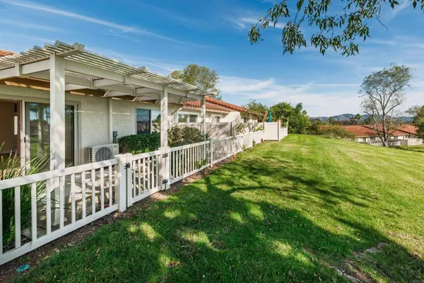a view of a house with a small yard and wooden fence