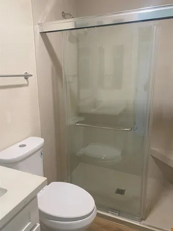 a white toilet sitting next to a shower