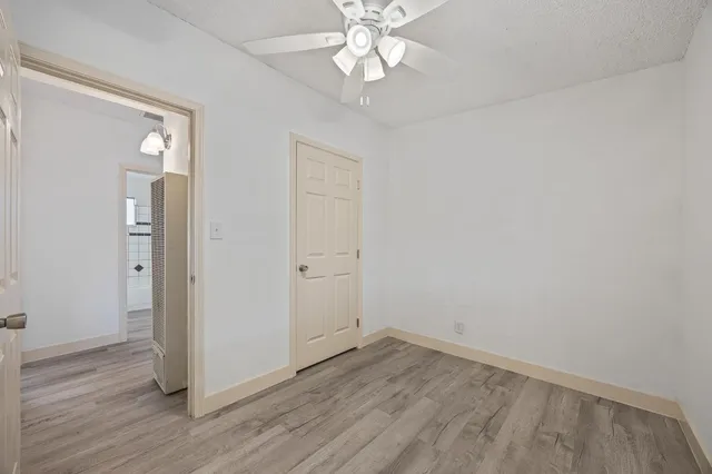 an empty room with wooden floor and door