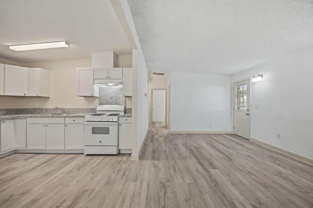 a kitchen with granite countertop a stove and cabinets