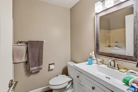 a bathroom with a toilet a sink and mirror