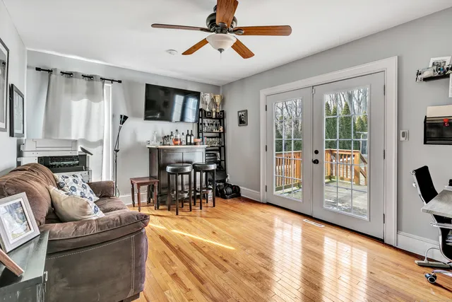 a living room with furniture a flat screen tv and a large window