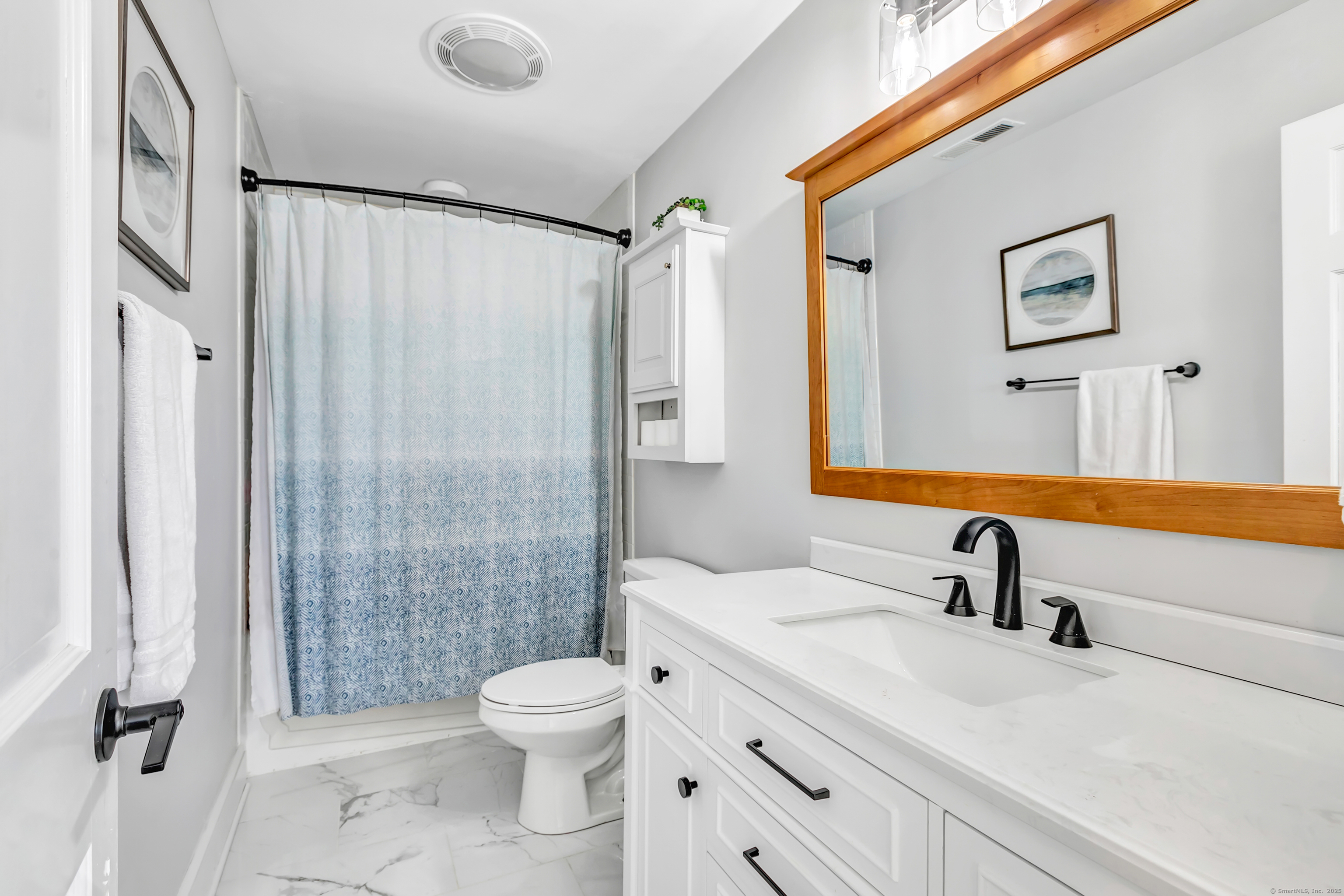 41 Mohawk Drive Norwalk, CT 06851 - Photo 25 of 31 a bathroom with a sink toilet a mirror a vanity and shower