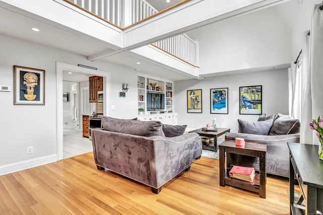 a living room with furniture and a wooden floor