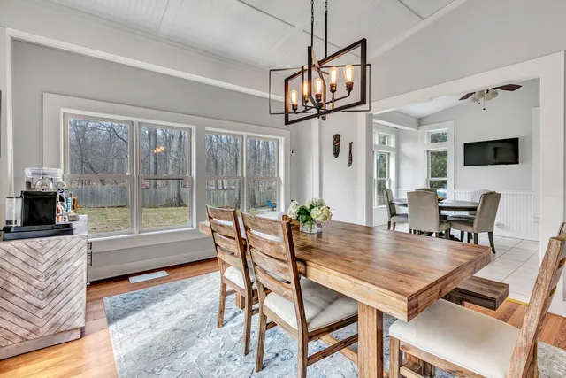 a dining room with furniture a chandelier and wooden floor