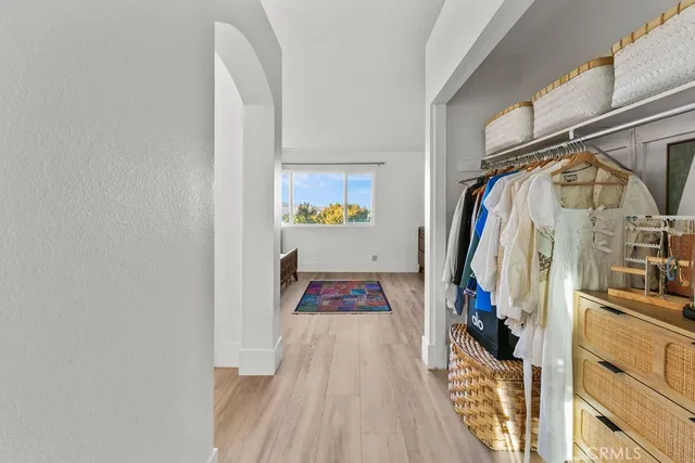 a view of walk in closet with clothes and shoes