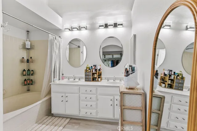 a bathroom with a double vanity sink mirror and bathtub