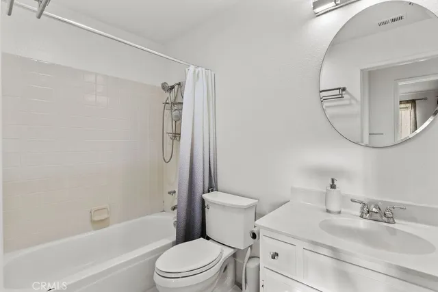 a bathroom with a granite countertop toilet a sink and a mirror