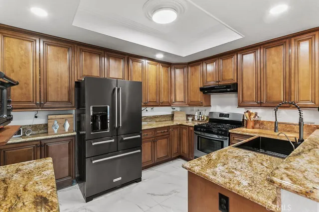 a kitchen with granite countertop stainless steel appliances cabinets and a sink