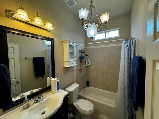a bathroom with a sink a toilet a mirror and shower