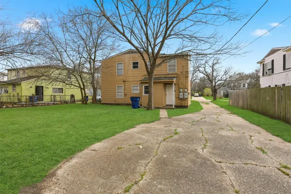 a view of a white house next to a yard and road