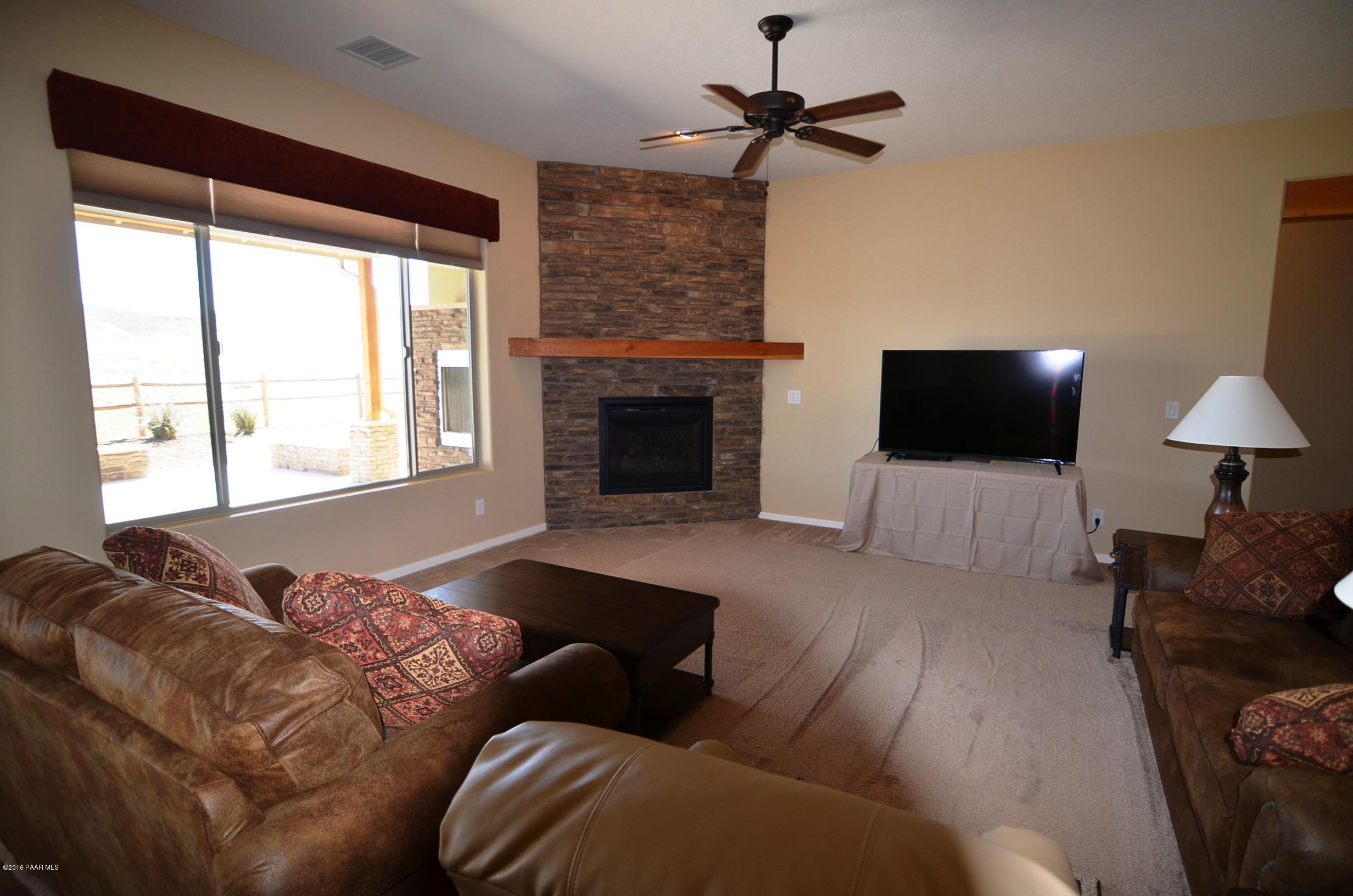 9474 Dows Ranch Road Prescott Valley, AZ 86315 - Photo 14 of 55 a living room with furniture and a fireplace