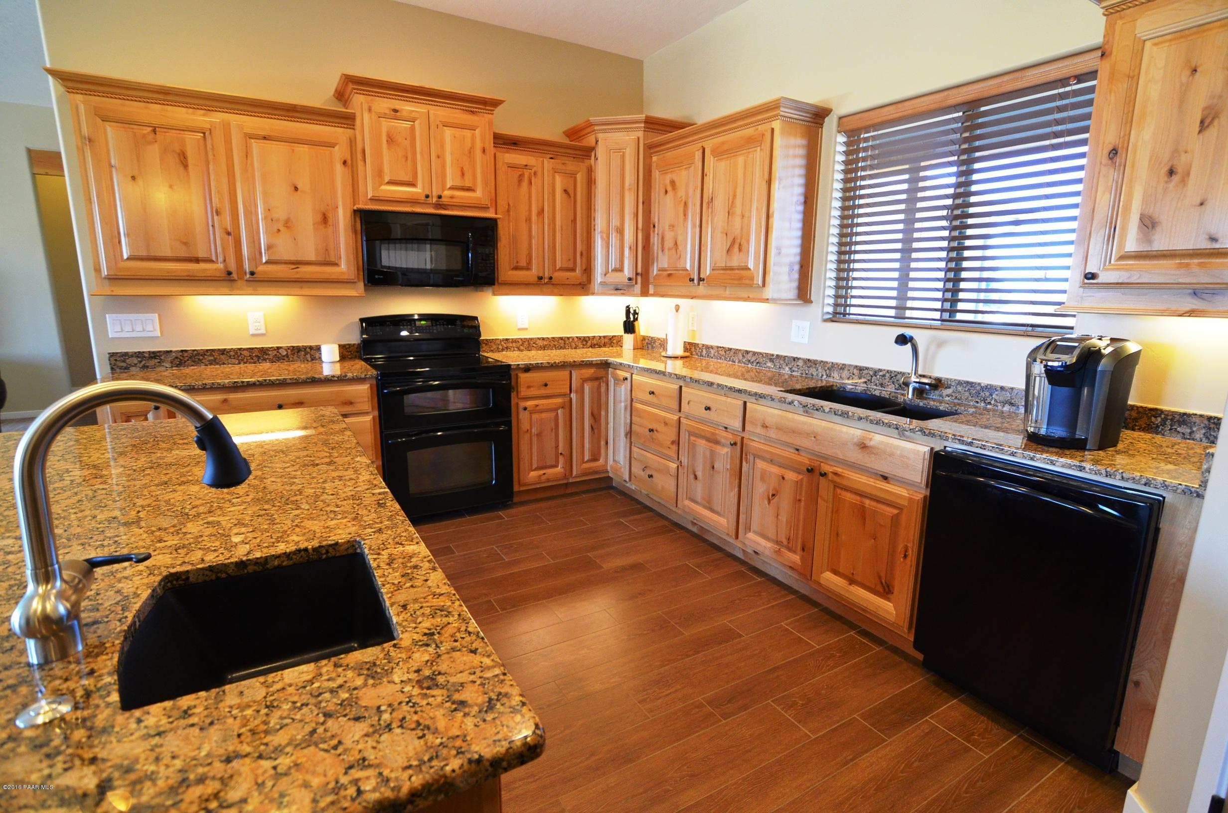 9474 Dows Ranch Road Prescott Valley, AZ 86315 - Photo 3 of 55 a kitchen with stainless steel appliances granite countertop a stove a sink and a microwave