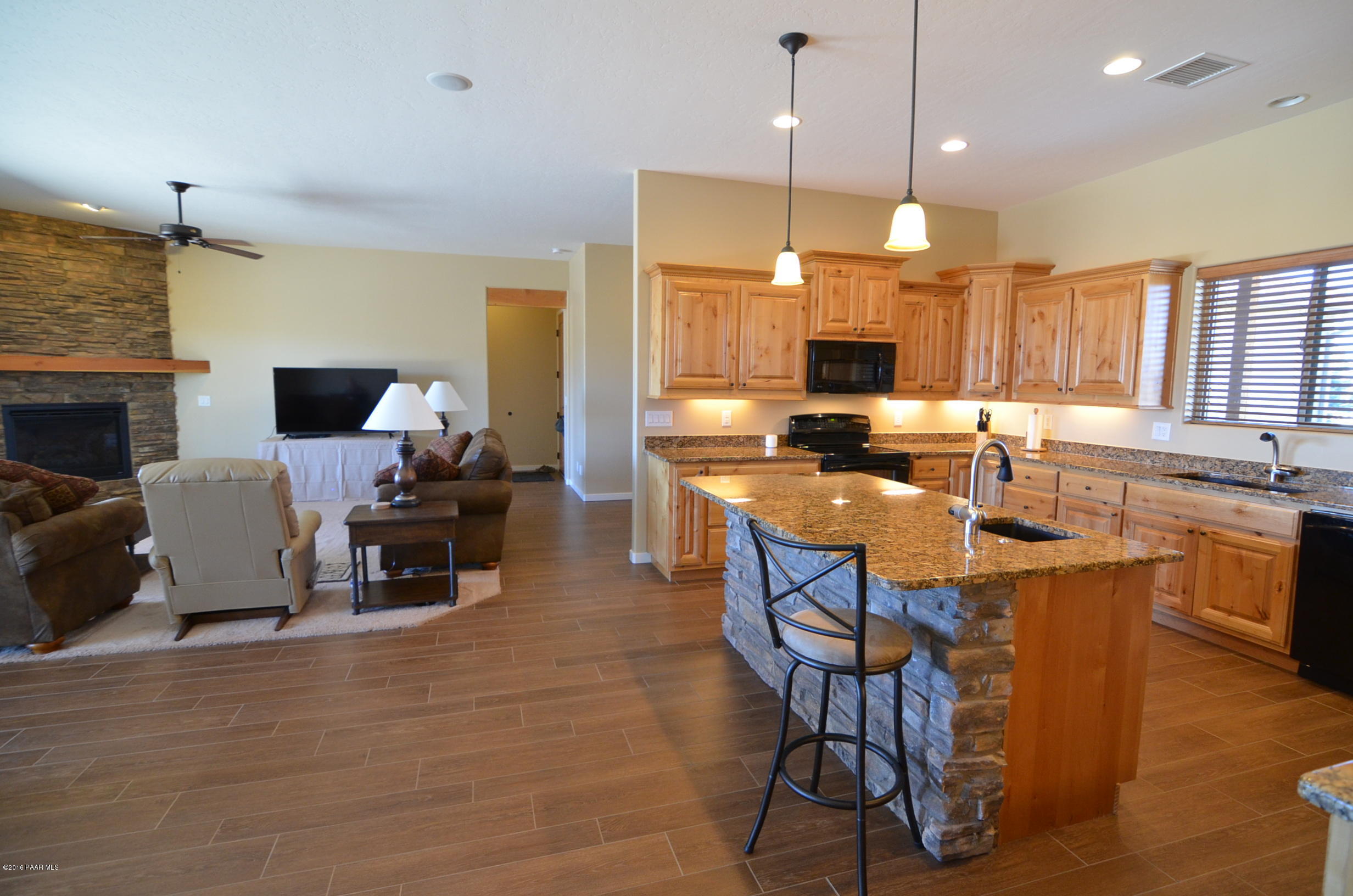 9474 Dows Ranch Road Prescott Valley, AZ 86315 - Photo 35 of 55 a kitchen with stainless steel appliances granite countertop a stove top oven a sink dishwasher a dining table and chairs with wooden floor