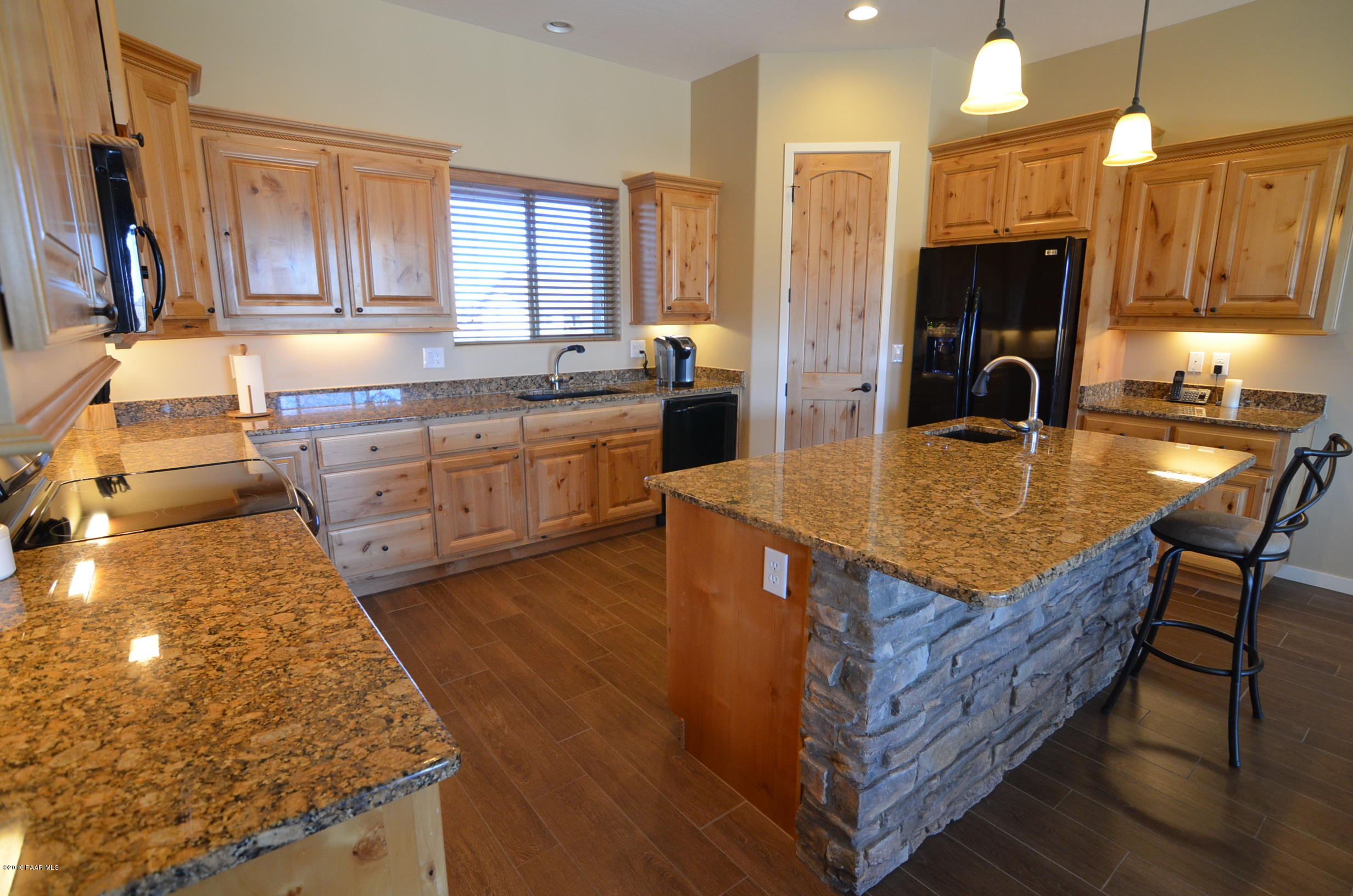 9474 Dows Ranch Road Prescott Valley, AZ 86315 - Photo 51 of 55 a kitchen with sink a refrigerator and wooden cabinets