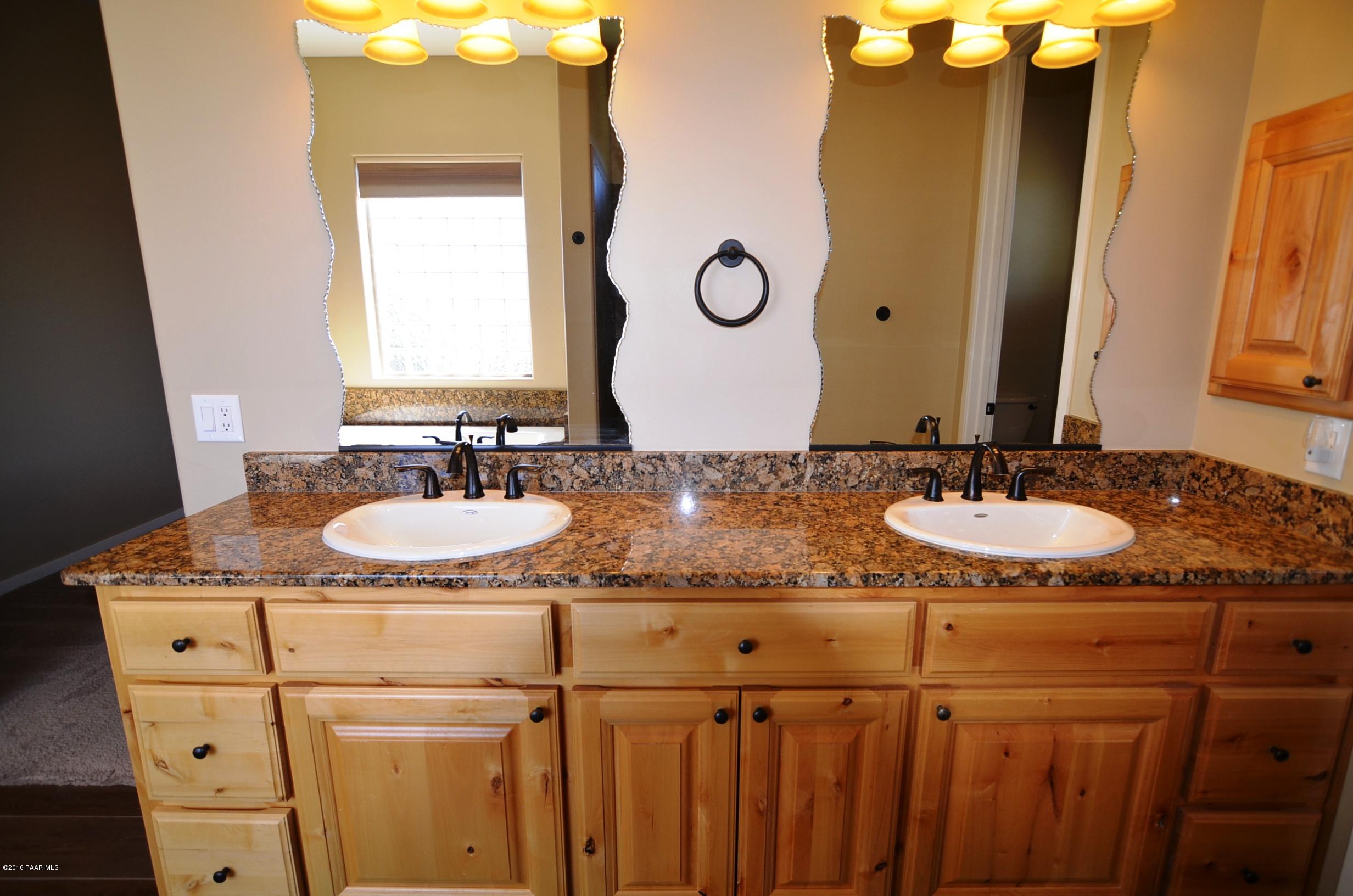 9474 Dows Ranch Road Prescott Valley, AZ 86315 - Photo 54 of 55 a bathroom with a granite countertop sink and a mirror