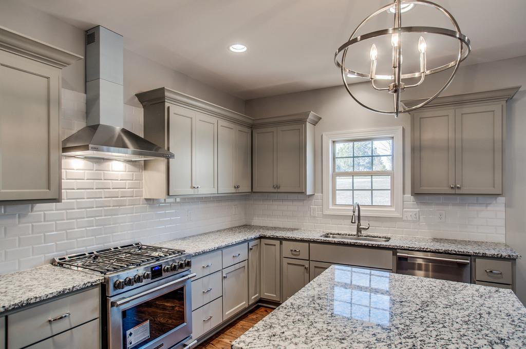 7314 Allans Ridge Lane Fairview, TN 37062 - Photo 14 of 30 a kitchen with stainless steel appliances granite countertop a sink stove and cabinets