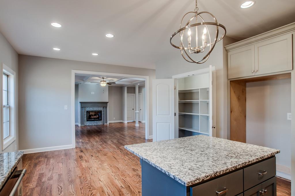 7314 Allans Ridge Lane Fairview, TN 37062 - Photo 15 of 30 a kitchen with granite countertop wooden floor and chandelier