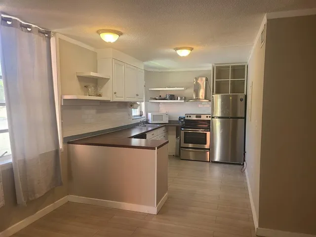 a kitchen with granite countertop a refrigerator and a sink