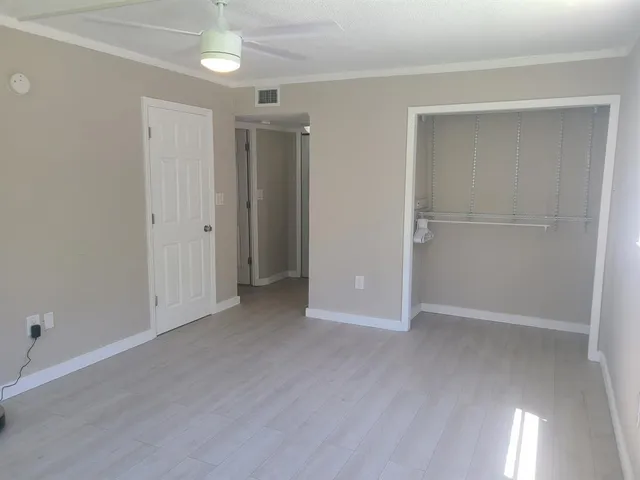 an empty room with closet and windows