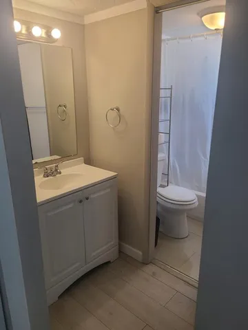 a bathroom with a sink a toilet and shower