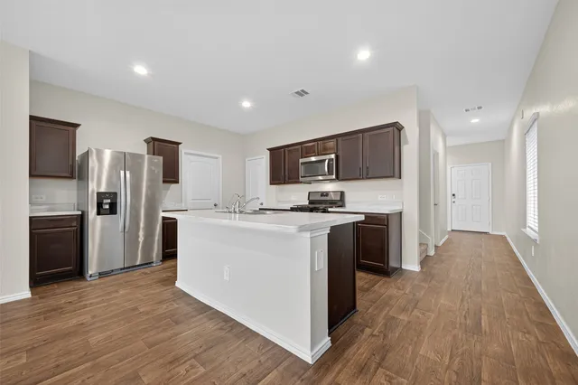 a kitchen with stainless steel appliances a refrigerator and a stove top oven