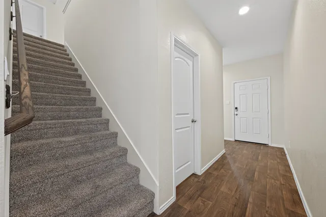 a view of a hallway with wooden floor and entryway