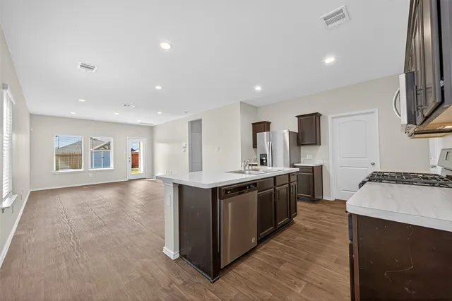 a large kitchen with stainless steel appliances granite countertop a stove and a sink