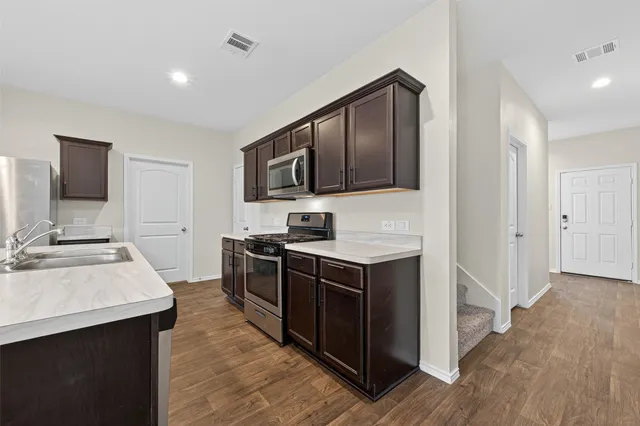 a kitchen with stainless steel appliances a stove sink and microwave