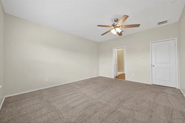 a view of empty room with ceiling fan