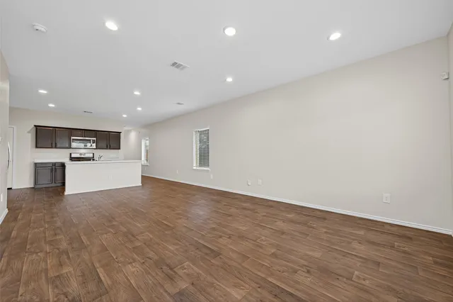 a view of a kitchen with white cabinets and wooden floor