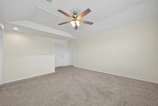 an empty room with chandelier fan and windows