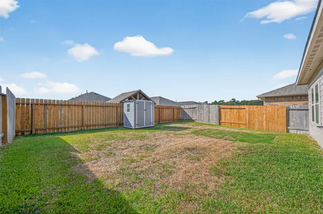 a view of a house with backyard and fence