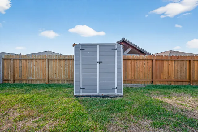 a view of a backyard with wooden fence
