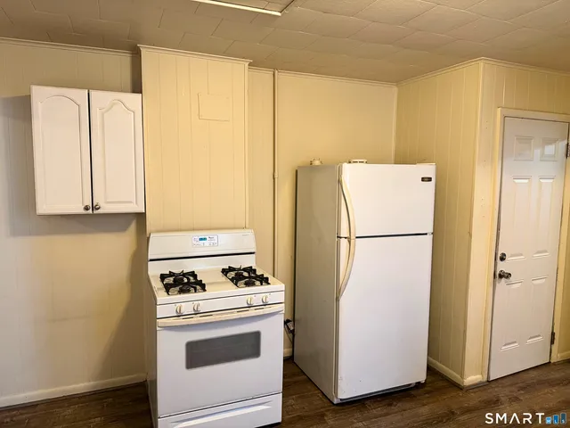 a white refrigerator freezer and a stove sitting inside of a kitchen