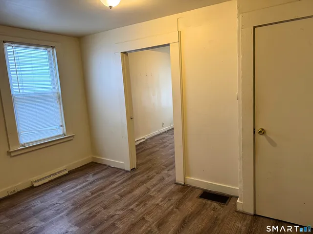an empty room with wooden floor and a window