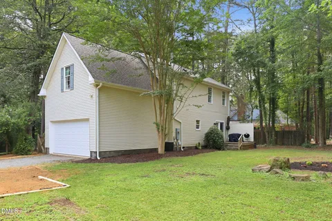 a view of a house with a backyard and a tree