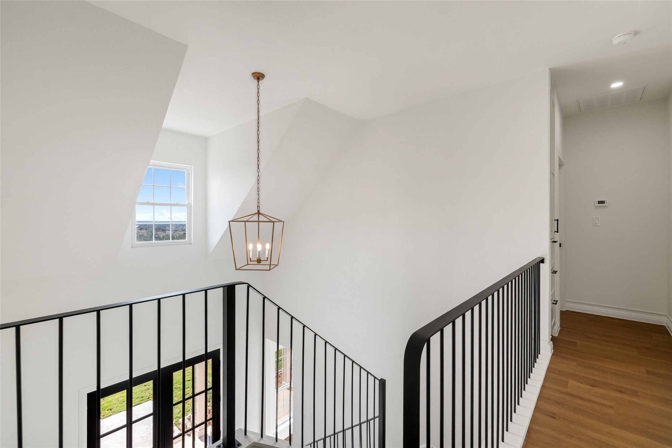 601 Hays Country Acres Road Dripping Springs, TX 78620 - Photo 30 of 38 Crisp white walls and clean hardwood floors frame an elegant upstairs landing and stairwell.