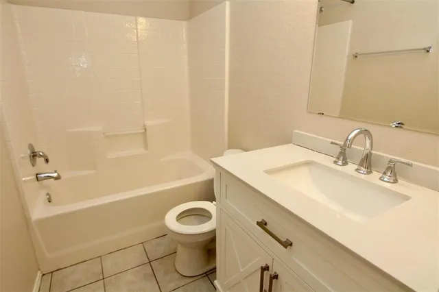 an empty room with a chandelier fan and windows