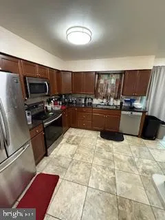 a kitchen with stainless steel appliances kitchen island granite countertop a refrigerator and a stove top oven