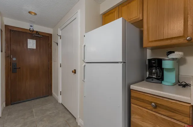 a kitchen with refrigerator and cabinets