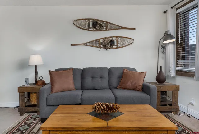 a living room with furniture rug and a lamp