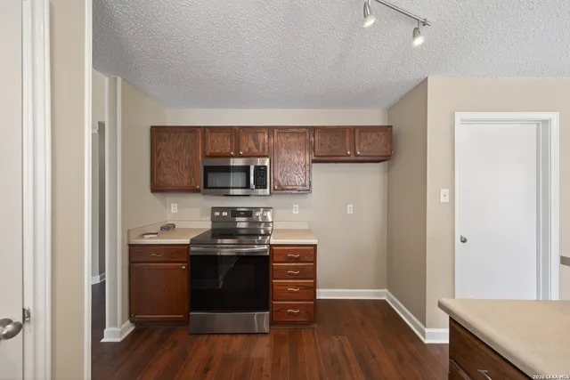 a kitchen with stainless steel appliances a stove top oven a sink and a refrigerator
