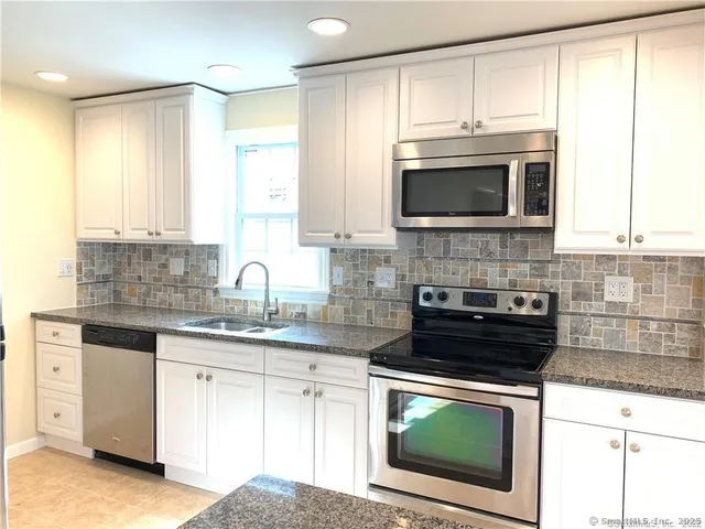 a kitchen with cabinets stainless steel appliances a sink and a microwave